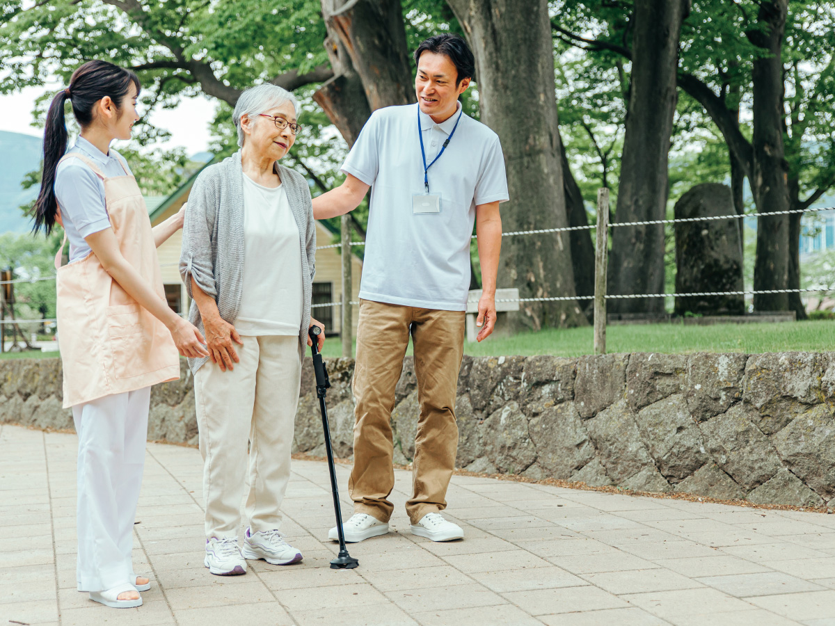 散歩する患者と施設スタッフ